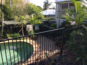 mewald building home with pool in backyard with a black fence